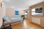 Experience cozy living in this charming room featuring a comfortable bed with light blue patterned bedding and plush pillows.