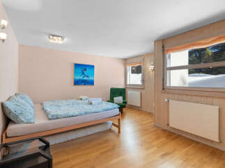 Experience cozy living in this charming room featuring a comfortable bed with light blue patterned bedding and plush pillows.