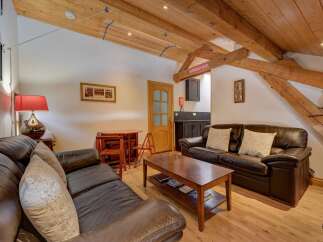 Step into this charming living space featuring exposed wooden beams and a cozy atmosphere.