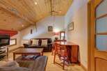 This charming property boasts a cozy living space with a comfortable leather sofa and a stylish wooden coffee table.