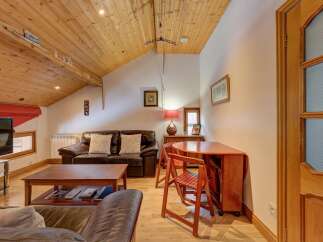 This charming property boasts a cozy living space with a comfortable leather sofa and a stylish wooden coffee table.