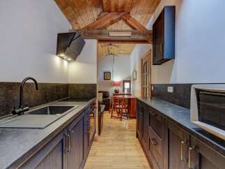 This stunning kitchen boasts a sleek, modern design with dark cabinetry and countertops, creating a sophisticated atmosphere.