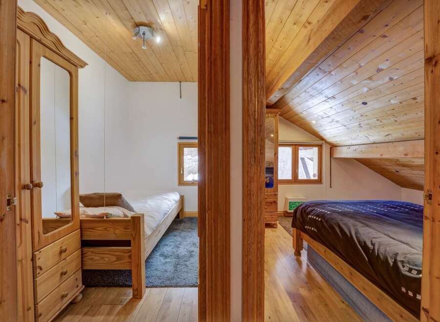 Discover the charm of this cozy bedroom, featuring warm wooden accents and a unique architectural design.