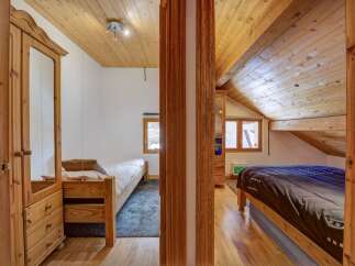 Discover the charm of this cozy bedroom, featuring warm wooden accents and a unique architectural design.