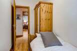 This charming bedroom features a cozy single bed with a stylish striped pillow.