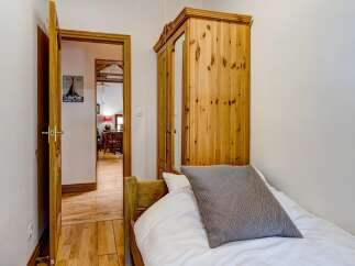This charming bedroom features a cozy single bed with a stylish striped pillow.