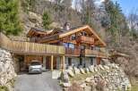 Discover a stunning wooden chalet nestled in a picturesque mountain setting.