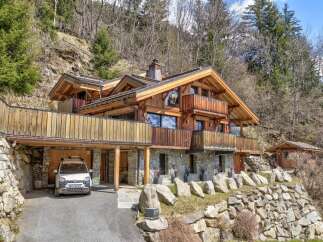 Discover a stunning wooden chalet nestled in a picturesque mountain setting.