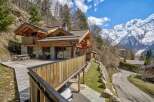 Nestled in a picturesque mountain setting, this stunning property boasts a beautiful wooden exterior and a spacious deck, perfect for enjoying the breathtaking views.