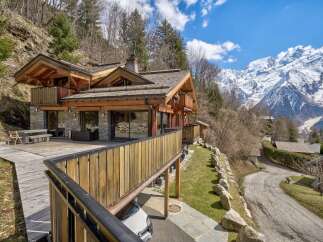 Nestled in a picturesque mountain setting, this stunning property boasts a beautiful wooden exterior and a spacious deck, perfect for enjoying the breathtaking views.