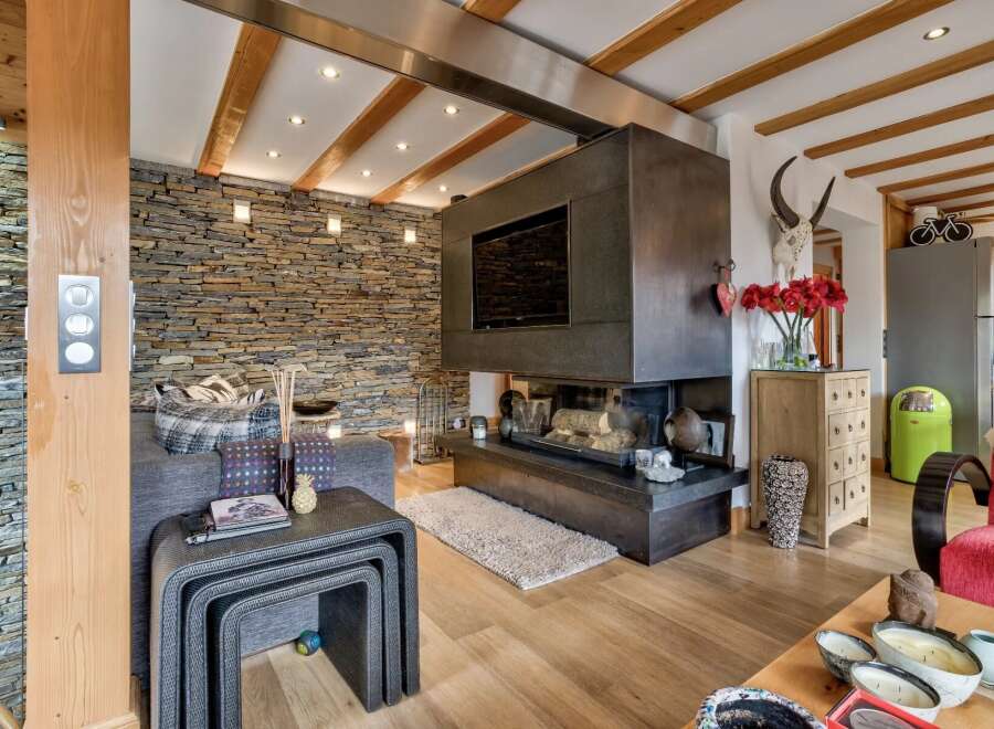 This stunning property boasts a cozy living room with a modern fireplace and a built-in TV, perfect for relaxing evenings.