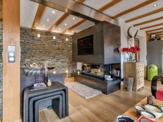 This stunning property boasts a cozy living room with a modern fireplace and a built-in TV, perfect for relaxing evenings.