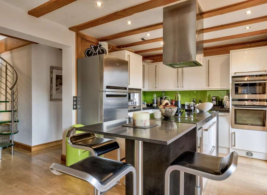 This stunning kitchen boasts a modern design with sleek stainless steel appliances and a stylish island.
