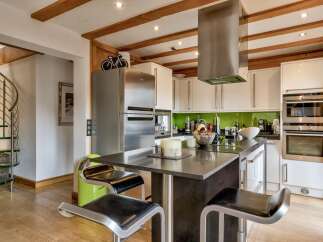 This stunning kitchen boasts a modern design with sleek stainless steel appliances and a stylish island.