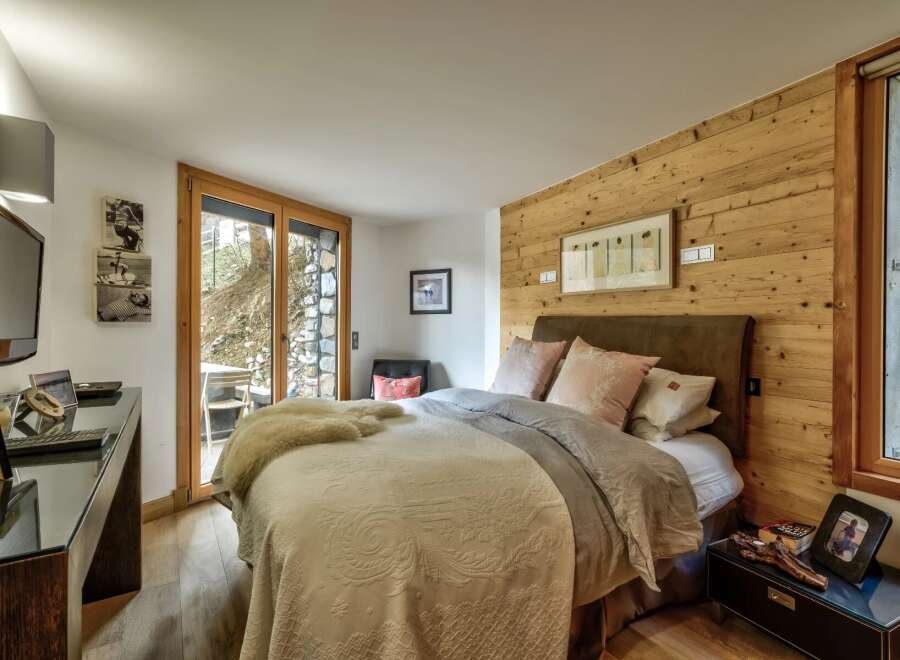 This cozy bedroom features a rustic wooden accent wall, creating a warm and inviting atmosphere.
