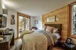 This cozy bedroom features a rustic wooden accent wall, creating a warm and inviting atmosphere.