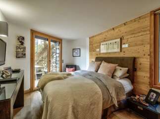 This cozy bedroom features a rustic wooden accent wall, creating a warm and inviting atmosphere.