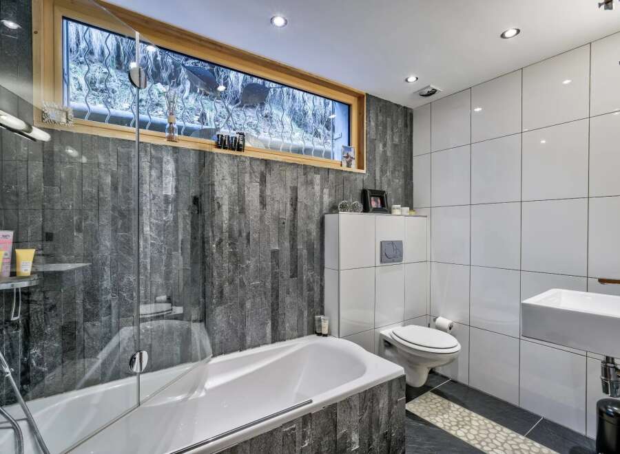 Step into a modern bathroom oasis! This stunning space features a sleek bathtub, a stylish sink, and a contemporary toilet.