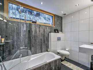 Step into a modern bathroom oasis! This stunning space features a sleek bathtub, a stylish sink, and a contemporary toilet.