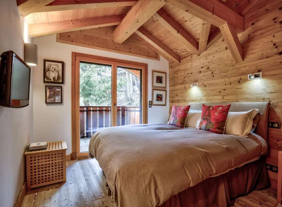 Experience the charm of this cozy bedroom featuring a rustic wooden ceiling and walls, creating a warm and inviting atmosphere.