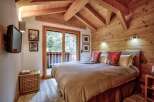 Experience the charm of this cozy bedroom featuring a rustic wooden ceiling and walls, creating a warm and inviting atmosphere.