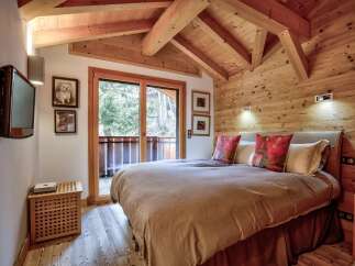Experience the charm of this cozy bedroom featuring a rustic wooden ceiling and walls, creating a warm and inviting atmosphere.