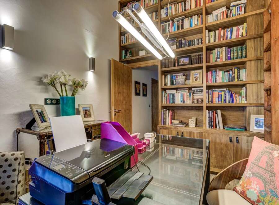 Discover the perfect home office setup in this stunning property! Featuring a built-in bookshelf, a sleek glass desk, and a modern printer, this space is designed for productivity and style.