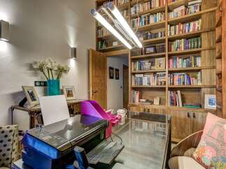 Discover the perfect home office setup in this stunning property! Featuring a built-in bookshelf, a sleek glass desk, and a modern printer, this space is designed for productivity and style.