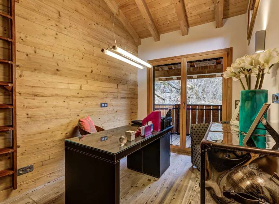 This stunning home office boasts a rustic charm with its wooden walls and ceiling, creating a warm and inviting atmosphere.