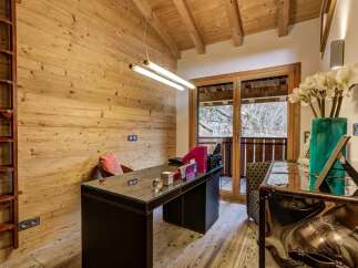This stunning home office boasts a rustic charm with its wooden walls and ceiling, creating a warm and inviting atmosphere.