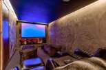Step into luxury with this stunning home theater! Featuring a large screen, comfortable seating, and ambient lighting, it's the perfect space for movie nights.