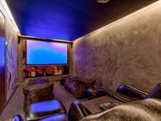 Step into luxury with this stunning home theater! Featuring a large screen, comfortable seating, and ambient lighting, it's the perfect space for movie nights.