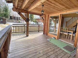 Discover the charm of this stunning property, featuring a spacious wooden deck perfect for enjoying the outdoors.