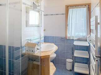 Discover this charming bathroom featuring a unique wooden vanity and a stylish shower enclosure.