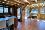 Step into this charming wooden cabin, featuring a cozy interior with exposed beams and warm wood paneling.