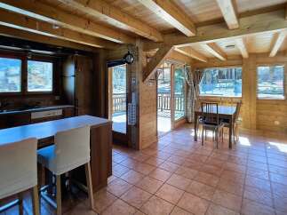 Step into this charming wooden cabin, featuring a cozy interior with exposed beams and warm wood paneling.