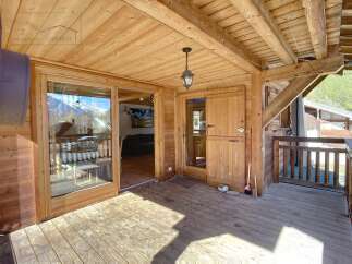 Discover the charm of this wooden chalet, featuring a spacious outdoor deck perfect for enjoying the mountain views.