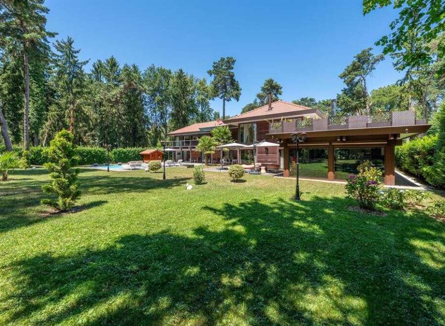 Discover luxury living in this stunning property, showcasing a meticulously manicured lawn and a beautiful outdoor space.