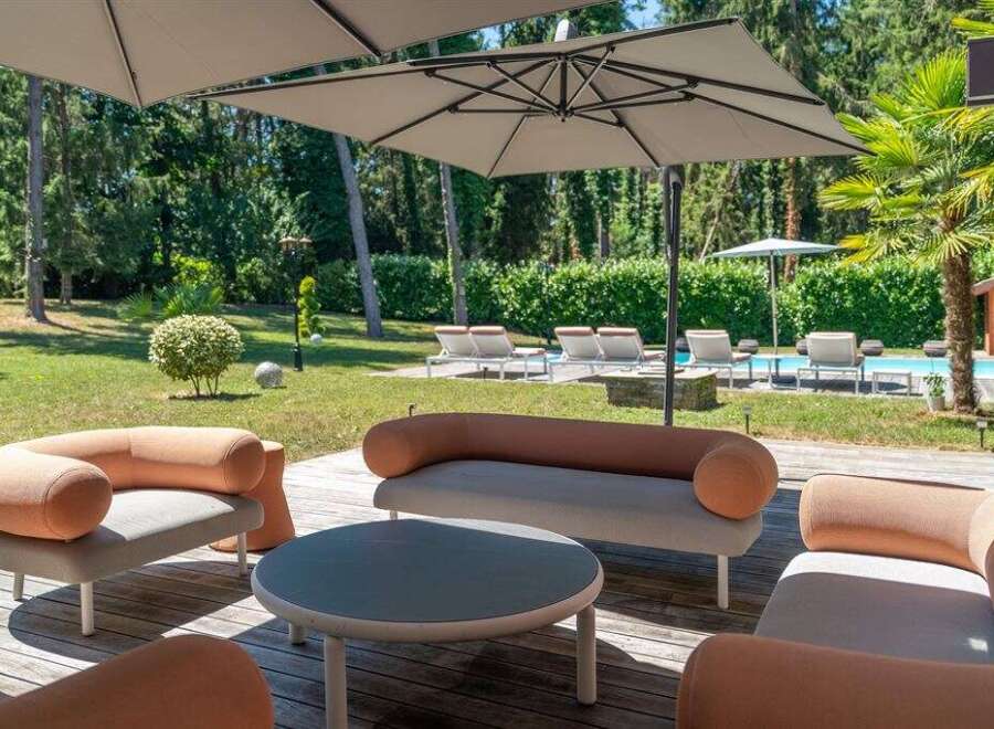 Enjoy luxurious outdoor living in this stunning property! This image showcases a beautifully designed patio area, complete with stylish seating and a modern round table.