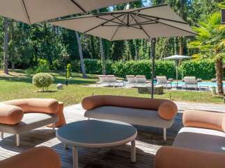 Enjoy luxurious outdoor living in this stunning property! This image showcases a beautifully designed patio area, complete with stylish seating and a modern round table.