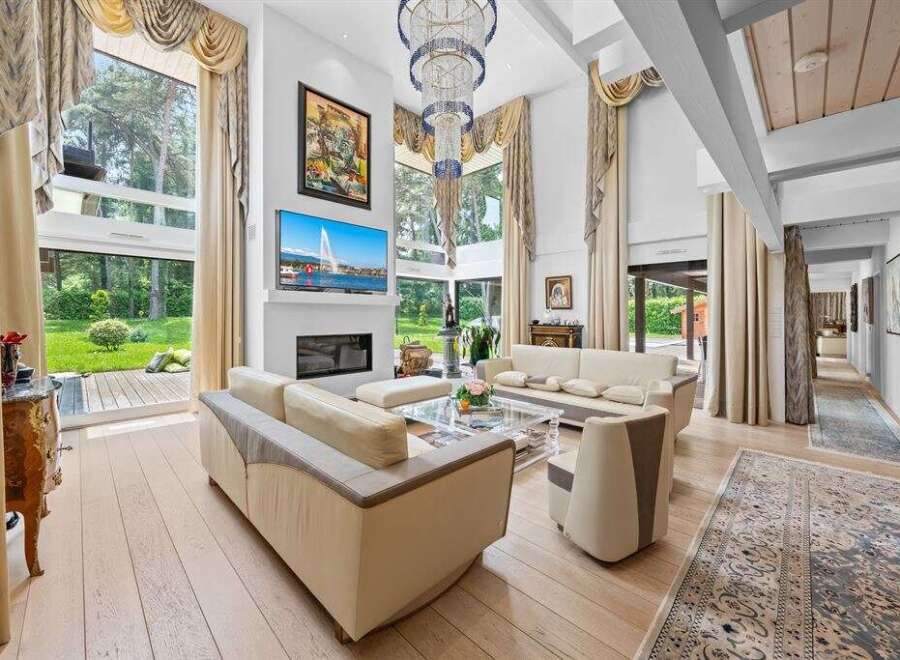 Experience luxury living in this stunning property, featuring a bright and airy living room with high ceilings and expansive windows.
