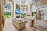 Experience luxury living in this stunning property, featuring a bright and airy living room with high ceilings and expansive windows.