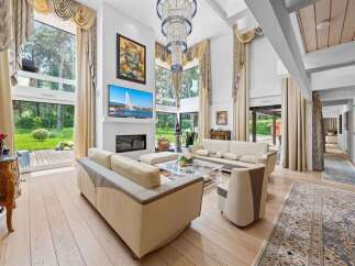 Experience luxury living in this stunning property, featuring a bright and airy living room with high ceilings and expansive windows.