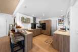 This stunning kitchen boasts modern design with sleek wooden cabinetry and countertops, creating a warm and inviting atmosphere.