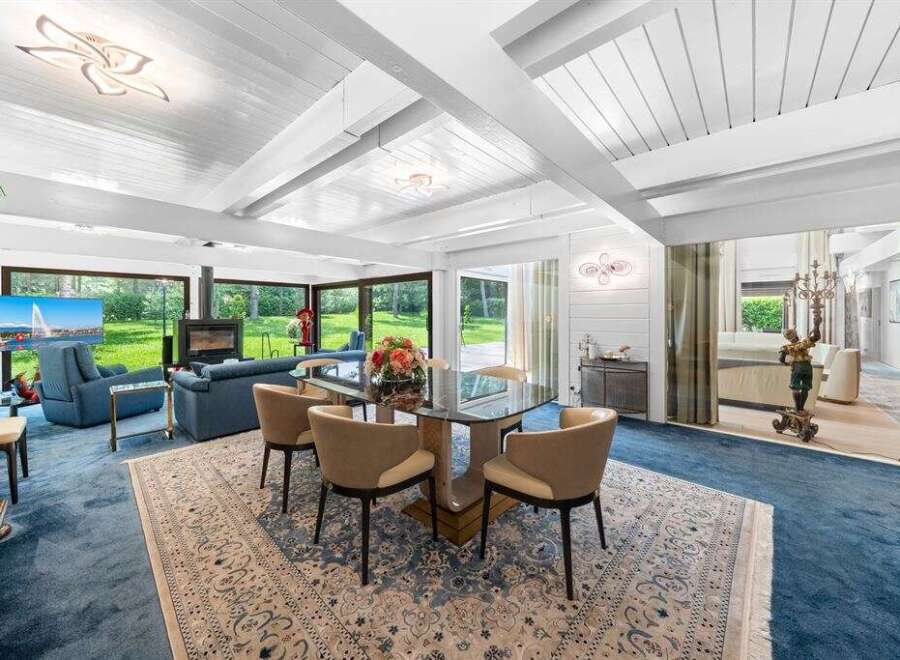 Experience luxury living in this stunning property, featuring a spacious dining area with a modern glass table and stylish chairs.