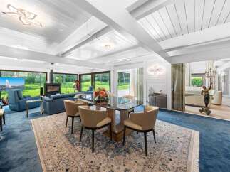 Experience luxury living in this stunning property, featuring a spacious dining area with a modern glass table and stylish chairs.