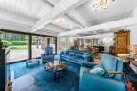 Experience luxury living in this stunning property, featuring a spacious living room with a plush blue carpet and comfortable seating.