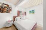 This charming bedroom features a cozy ambiance with its soft color palette and stylish decor.