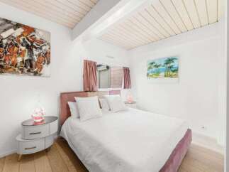 This charming bedroom features a cozy ambiance with its soft color palette and stylish decor.