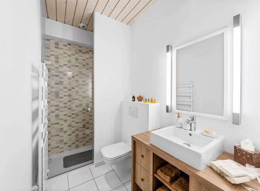 This modern bathroom features a sleek design with a wooden vanity and a stylish sink.